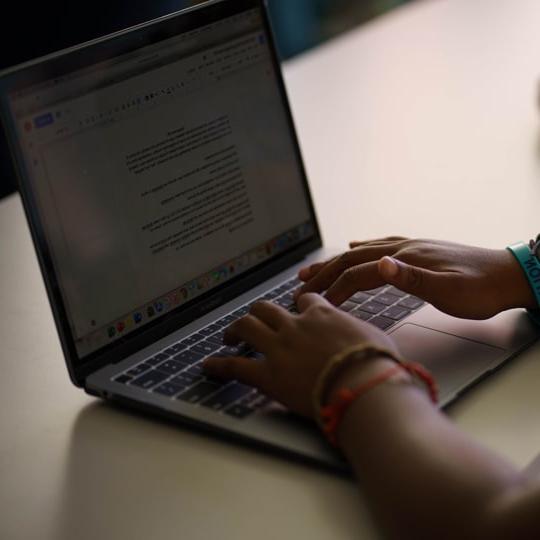 Photo of hands typing on a laptop